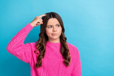 Photo of doubtful unsure lady wear pink sweater finger head looking empty space isolated blue color background. clipart