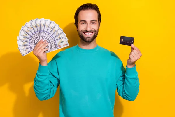 正のファンキーな男の写真は ターコイズブルーの服を着て上昇お金ファンバンクカード絶縁黄色の背景 — ストック写真