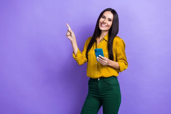 Photo of positive adorable lovely lady wear stylish clothes arm direct empty space buy gadget device isolated on purple color background.