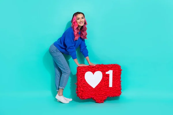 Full length photo of hipster curly dyed pink hair lady blogger star hold red paper pinata like symbol social media isolated on cyan color background.