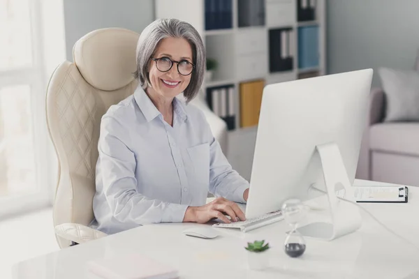 成功したスマート高齢女性弁護士の写真革の椅子キーボードに座っている電子メールの同僚のオフィスを書く内部 — ストック写真