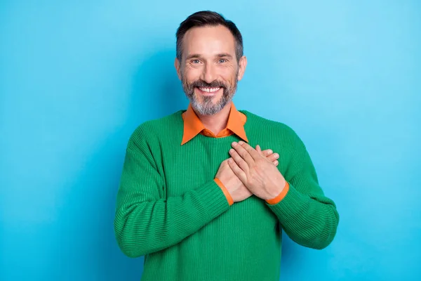 Photo of satisfied glad person toothy smile arms palms touch heart isolated on blue color background.