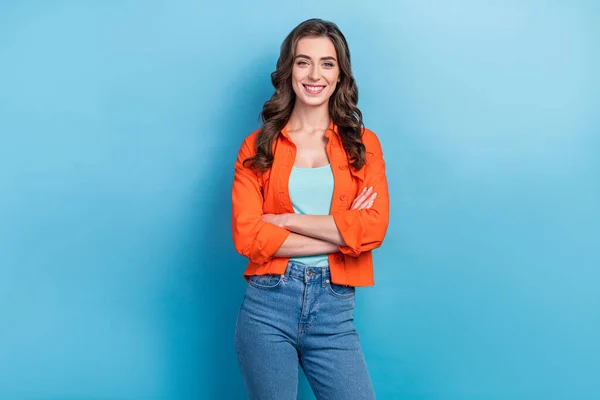 Photo of young successful project manager student girl wear orange stylish shirt folded arms enjoy prestigious job isolated on blue color background.