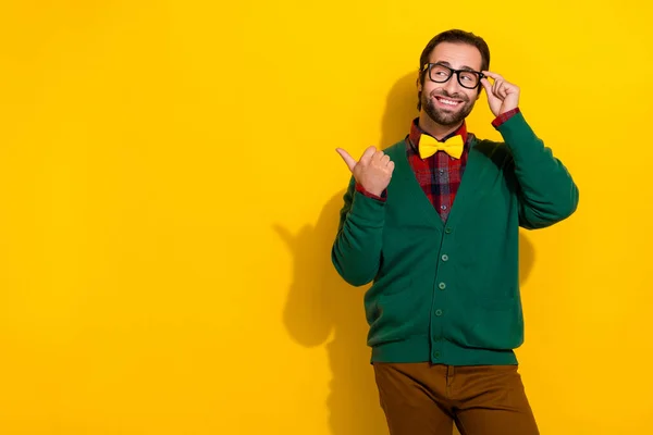 Photo portrait of attractive male touch specs point empty space toothy smile dressed stylish green look isolated on yellow color background.