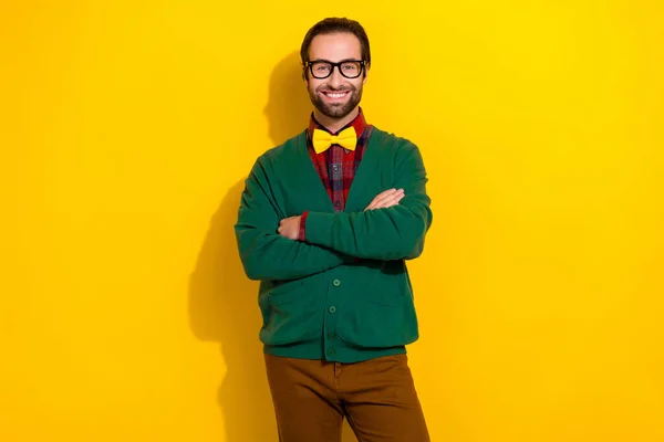 Photo portrait of young nice guy spectacles crossed arms beaming smile dressed stylish green clothes isolated on yellow color background.