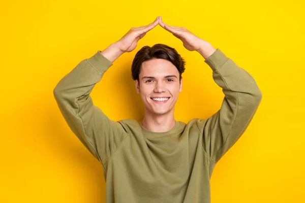 Photo of positive friendly person arms demonstrate roof gesture above head isolated on yellow color background.