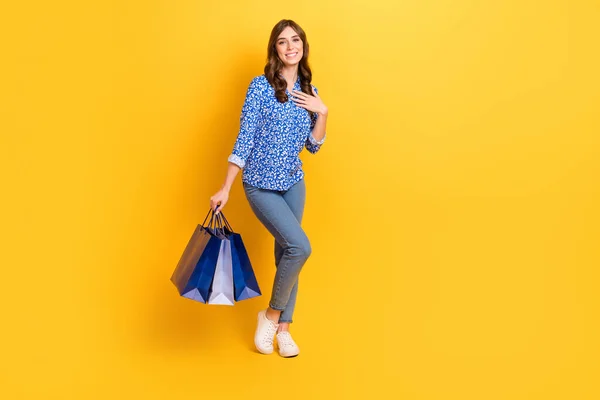Full body portrait of pretty lady hold boutique packages empty space proposition isolated on yellow color background.