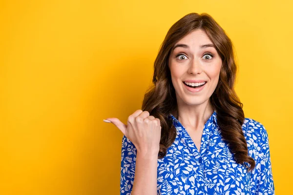 Photo of young astonished crazy positive business lady wear blue shirt direct finger empty space good crazy news isolated on yellow color background.