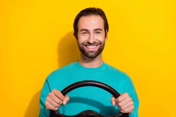 Photo of good mood pretty guy dressed teal outfit driving car smiling isolated yellow color background.