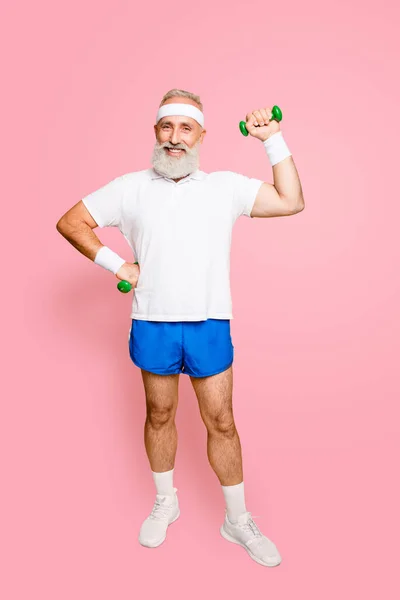Full length of cheerful emotional cool grandpa with humor grimace exercising holding equipment, lifts it with strength and power. Body care, hobby, weight loss, lifestyle, game process.