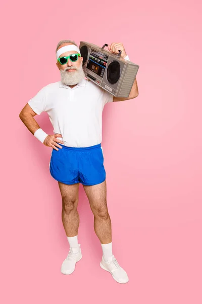 Crazy aged funny active sexy athlete pensioner grandpa in eyewear with bass clipping ghetto blaster recorder. Old school, swag, fooling around, gym, workout, technology, groove.