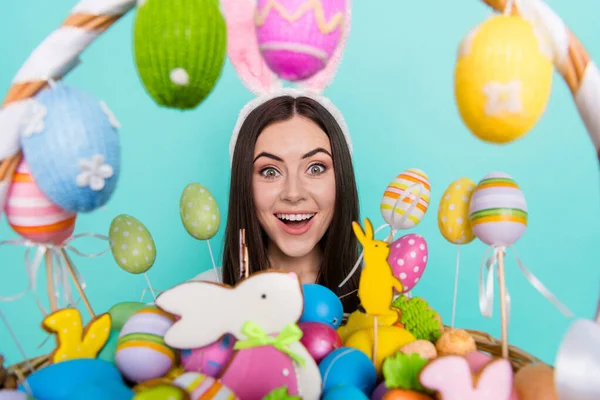 Photo of funky excited lady dressed striped pullover hare headband holding colorful easter eggs isolated teal color background.