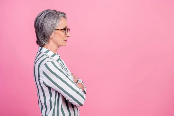 Profile photo of old mature aged senior entrepreneur seo company woman folded arms look empty space offer isolated on pink color background.