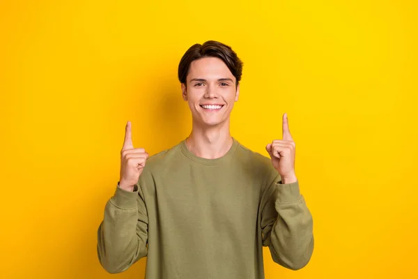 Photo of glad nice man wear quality outfit two arm direct empty space promoting new device shop isolated on yellow color background.