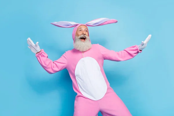 良い気分の写真楽観的な男はピンクのウサギの衣装を着て空のスペースが青い色の背景に隔離されたヤシの翼を飛んで見える — ストック写真