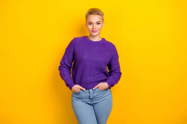 Photo of rich lady blonde short hair put hands pockets jeans wear stylish expensive purple knit trendy jumper isolated on yellow color background.