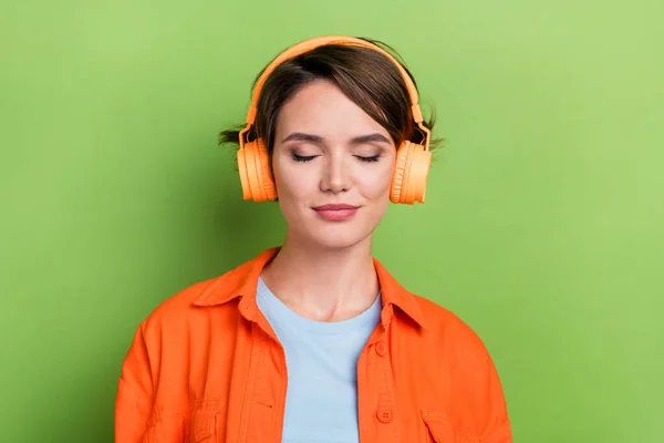 Photo of adorable dreamy lady wear bright trendy clothes listening favorite hit track isolated on green color background.