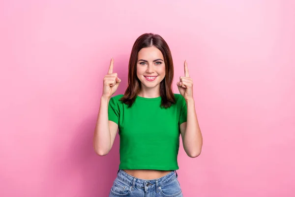 Portrait of cheerful sweet lady toothy smile direct fingers up empty space isolated on pink color background.