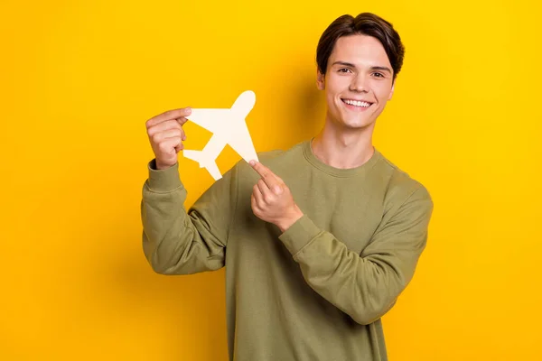Photo of positive satisfied person hands fingers hold little paper plane isolated on yellow color background.