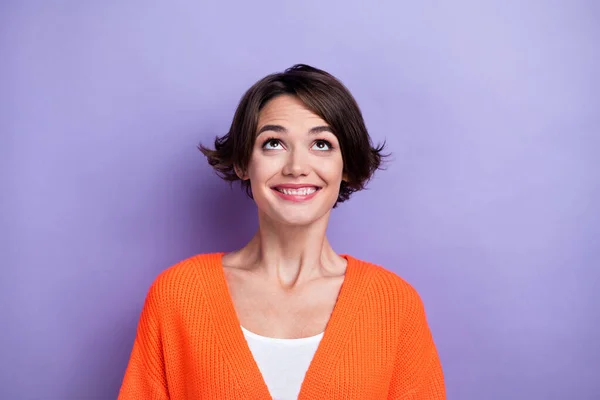 Photo of excited funky lady dressed orange cardigan looking up empty space isolated purple color background.