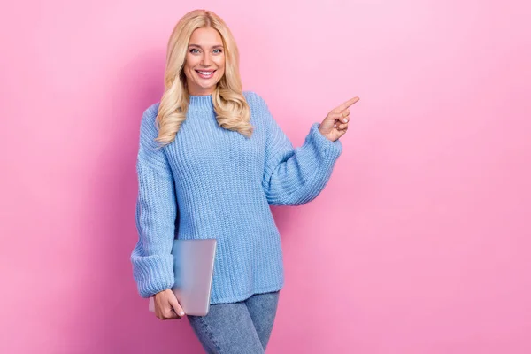 Photo of charming pretty lady wear blue clothes presenting modern device shop empty space isolated on pink color background.