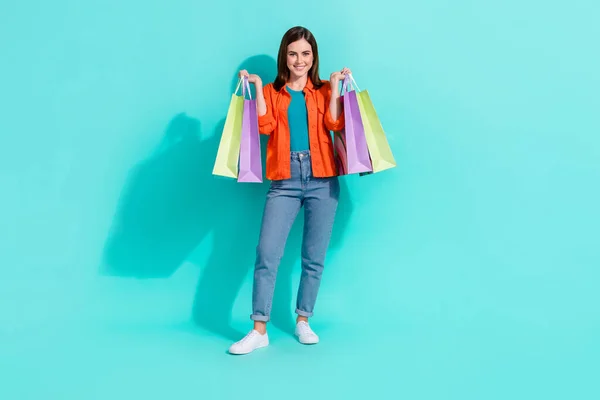 Full length photo of funny excited lady wear orange shirt rising bargains smiling isolated teal color background.