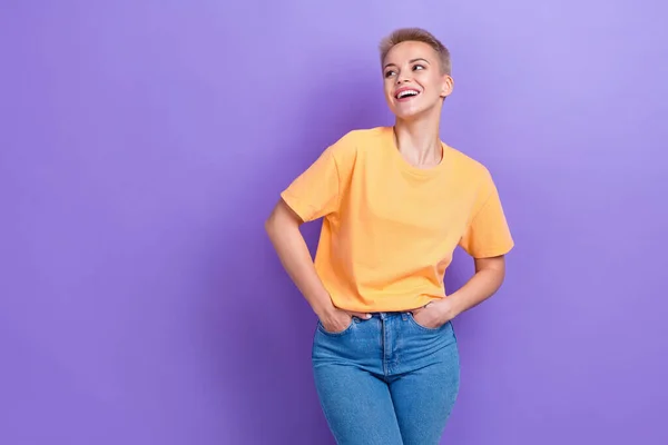 Photo of laughing good mood positive pretty woman looking empty space hands pockets good brand model posing isolated on purple color background.