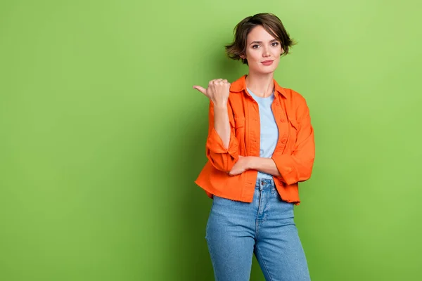 Photo of gorgeous lovely serious lady wear stylish clothes demonstrate empty space special offer deal isolated on green color background.