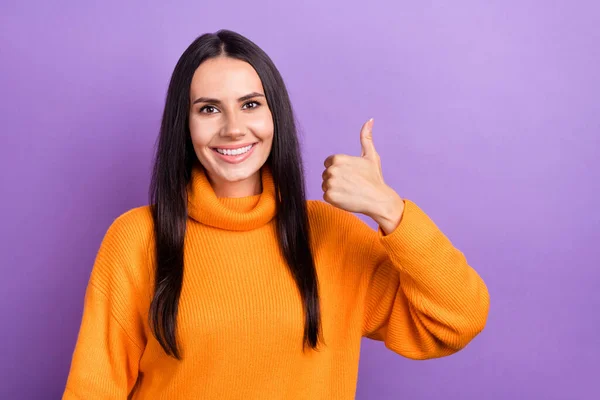 Photo of young positive cheerful woman wear orange stylish pullover thumb up recommend new advert best service isolated on violet color background.