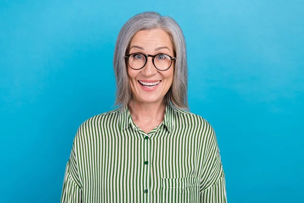 Photo of excited funny senior lady agent dressed striped shirt spectacles working despite of age isolated blue color background.