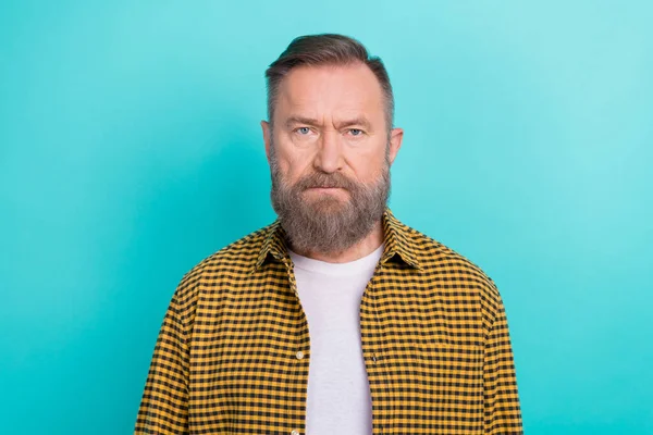 Closeup photo portrait of middle aged serious grimace face man grey beard wear yellow plaid shirt job vacancy isolated on cyan color background.