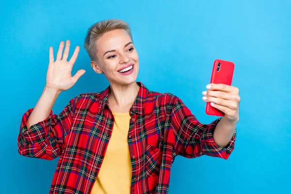 Photo of nice girl with short hairstyle dressed shirt look at phone instagram facebook whatsapp twitter isolated on blue color background.
