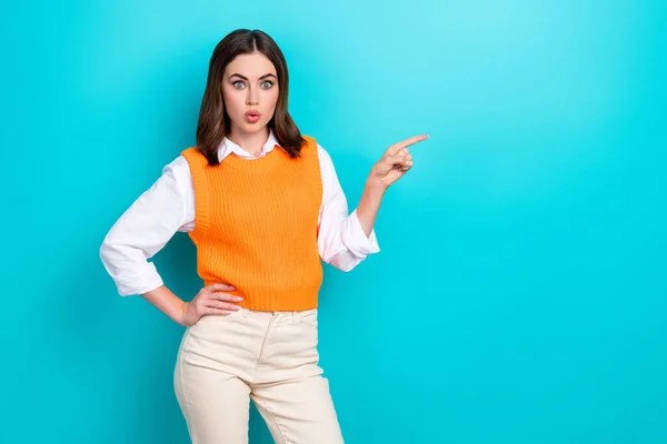Photo of impressed staring woman with bob hairstyle dressed orange waistcoat indicating empty space isolated on teal color background.