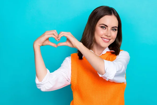 Photo of satisfied grateful appreciative woman bob hairstyle orange waistcoat fingers showing heart isolated on teal color background.