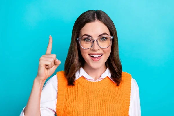 Photo of good mood funny cute clever woman with bob hairstyle orange waistcoat raise finger up good idea isolated on teal color background.