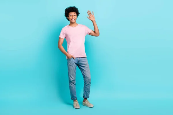 Full length body size photo of friendly good mood guy wear casual look wave palm hello palm high five isolated on aquamarine color background.