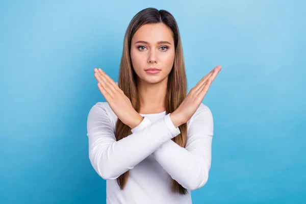 Photo of adorable serious lady dressed white shirt arms crossed showing stop gesture isolated blue color background.