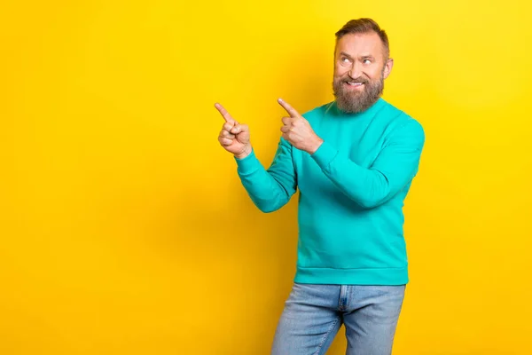 Photo portrait of attractive grandpa point empty space look excited wear trendy aquamarine clothes isolated on yellow color background.