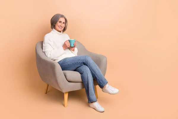 甘いです光沢のある女性の完全な長さの写真は ニットプルオーバーお茶を飲む空のスペース孤立ベージュ色の背景 — ストック写真