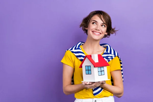 照片上快乐可爱的女士穿着时髦的衣服看起来空荡荡的 空旷的空间提供房屋销售代理孤立的紫色背景 — 图库照片