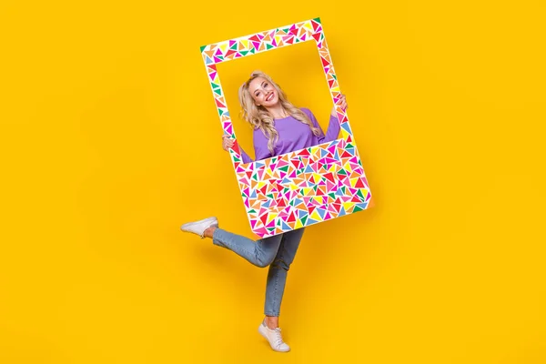 フルサイズの写真のかなり若い女の子ホールド瞬間写真フレームブロガーポーズ身に着けているトレンディーな紫色の服黄色の背景に隔離 — ストック写真