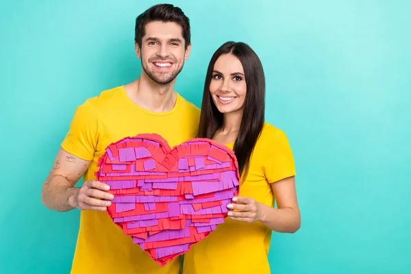 情侣们笑容满面的照片 身穿黄色T恤 手持纸制粉红明信片 情人节礼物 一面用青色背景隔开的宣传横幅 — 图库照片
