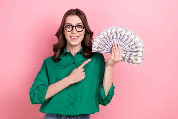 Portrait of shocked positive person indicate finger hand hold usd dollar bills banknotes isolated on pink color background.