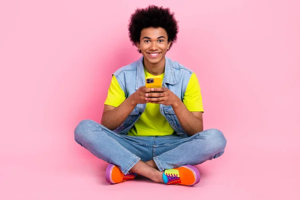 全长照片 快乐快乐的男人穿着时髦的衣服 坐在广告的新奇装置上 用粉色背景隔开 — 图库照片