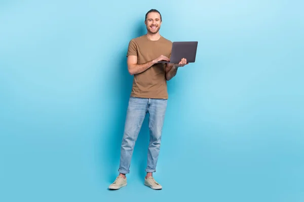 フル長いです写真のかなり陽気な男ドレスベージュTシャツ作業リンゴサムスン現代デバイス隔離された青の色の背景 — ストック写真