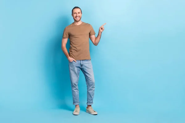 성격의 긍정적 남성의 사진빈 공간을 가리키는 베이지 티셔츠를 — 스톡 사진