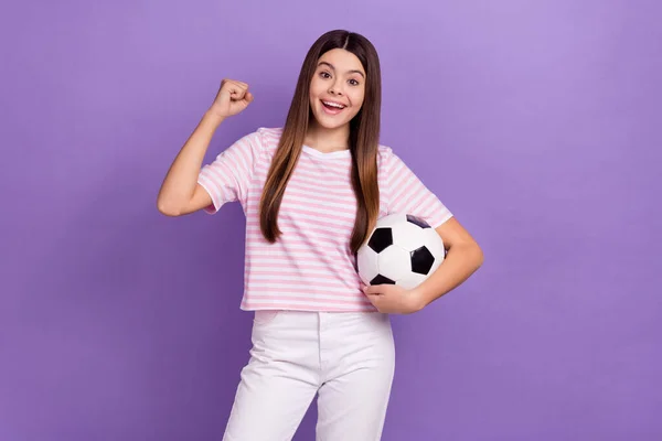 喜びのファンキーな女の子の肖像 ホールドサッカーは紫の色の背景に隔離された拳の成功の達成を上げる — ストック写真