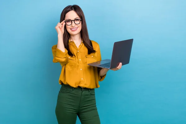 笑的照片年轻的女士黑发穿着黄衬衫绿裤子固定镜片拿着电脑老板的办公室隔离在蓝色背景下 — 图库照片