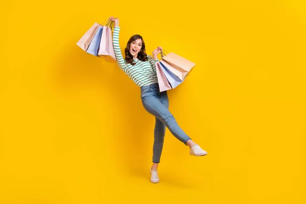 낙관적 인상을 소녀의 사진노란 배경에 고립된 쇼핑백을 비린내나는 줄무늬 — 스톡 사진