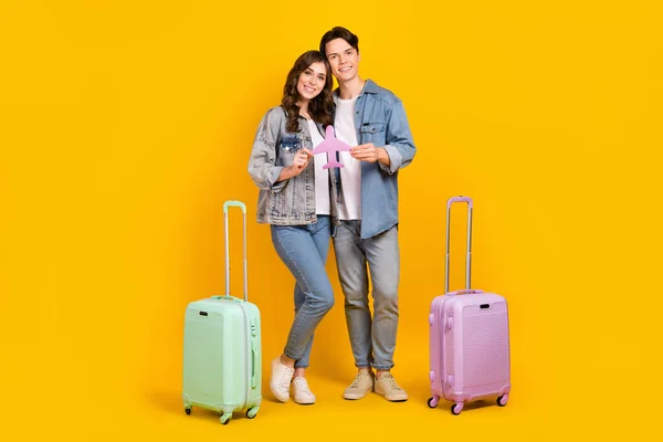 stock image Full length photo of pretty sweet couple dressed denim going trip holding paper plane isolated yellow color background.